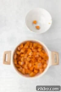 A pot filled with water and sweet potato cubes.