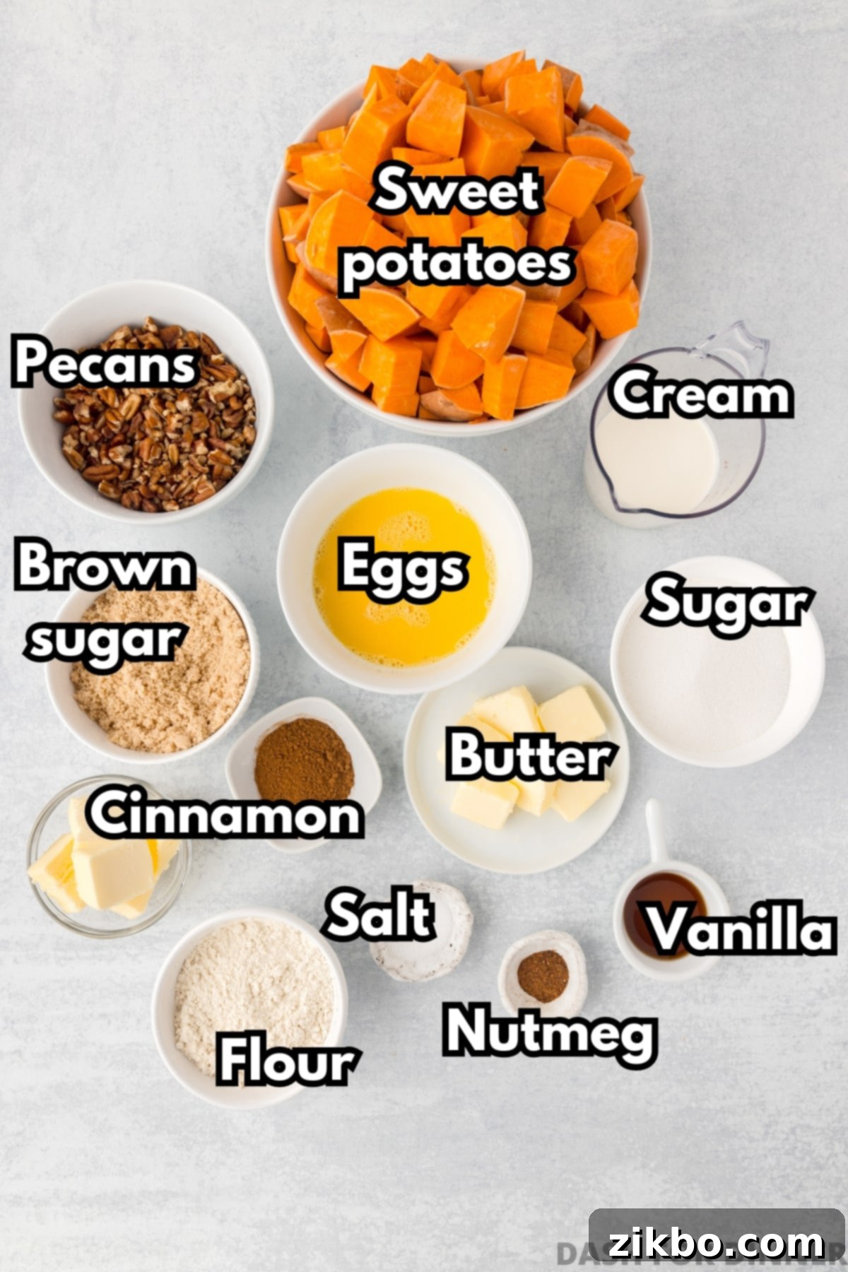 The ingredients needed to make sweet potato casserole, including butter, eggs, brown sugar, pecans, and cream, neatly arranged.