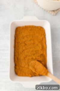 Spreading sweet potato casserole into a baking dish.