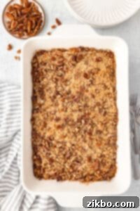 Sweet potato casserole in a large white baking dish, topped with pecans.