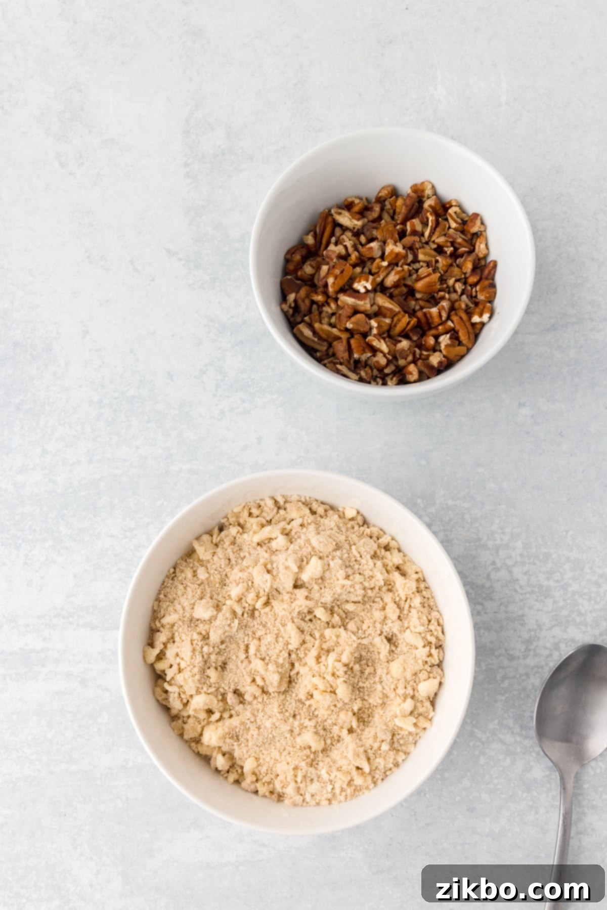 A streusel mixture with pecans on the side, showing the crumbly texture of the topping.
