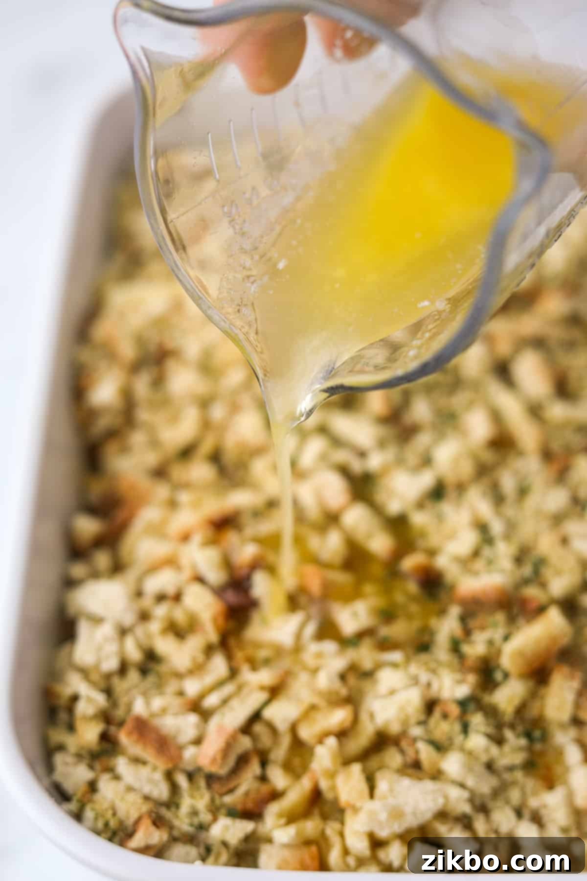 Drizzling melted butter over the dry stuffing and chicken casserole layer.