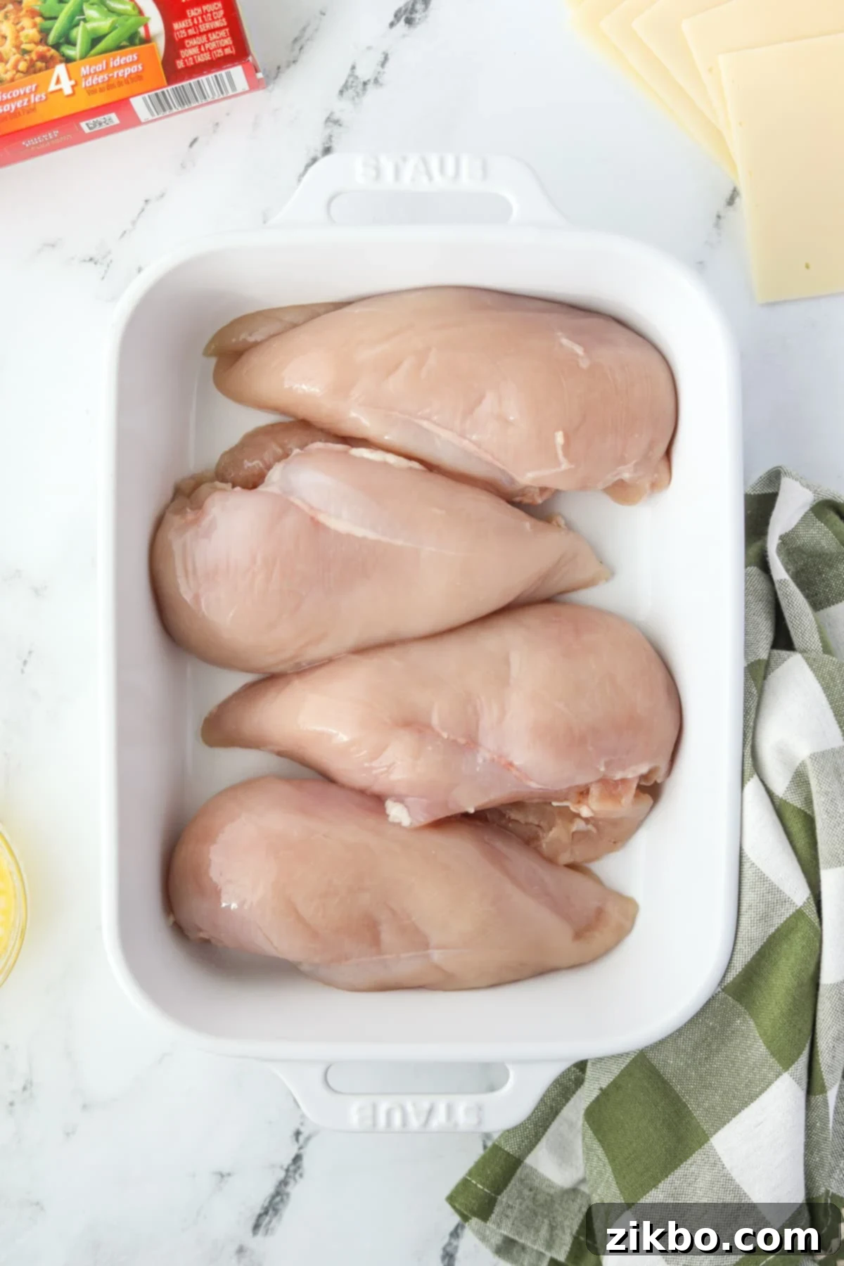 A baking dish with 4 chicken breasts arranged in a single layer.