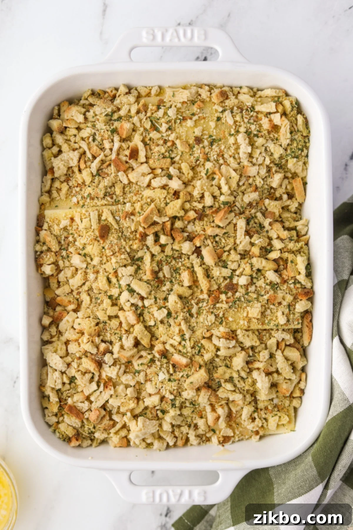 A baking dish casserole topped evenly with dry stuffing mix.
