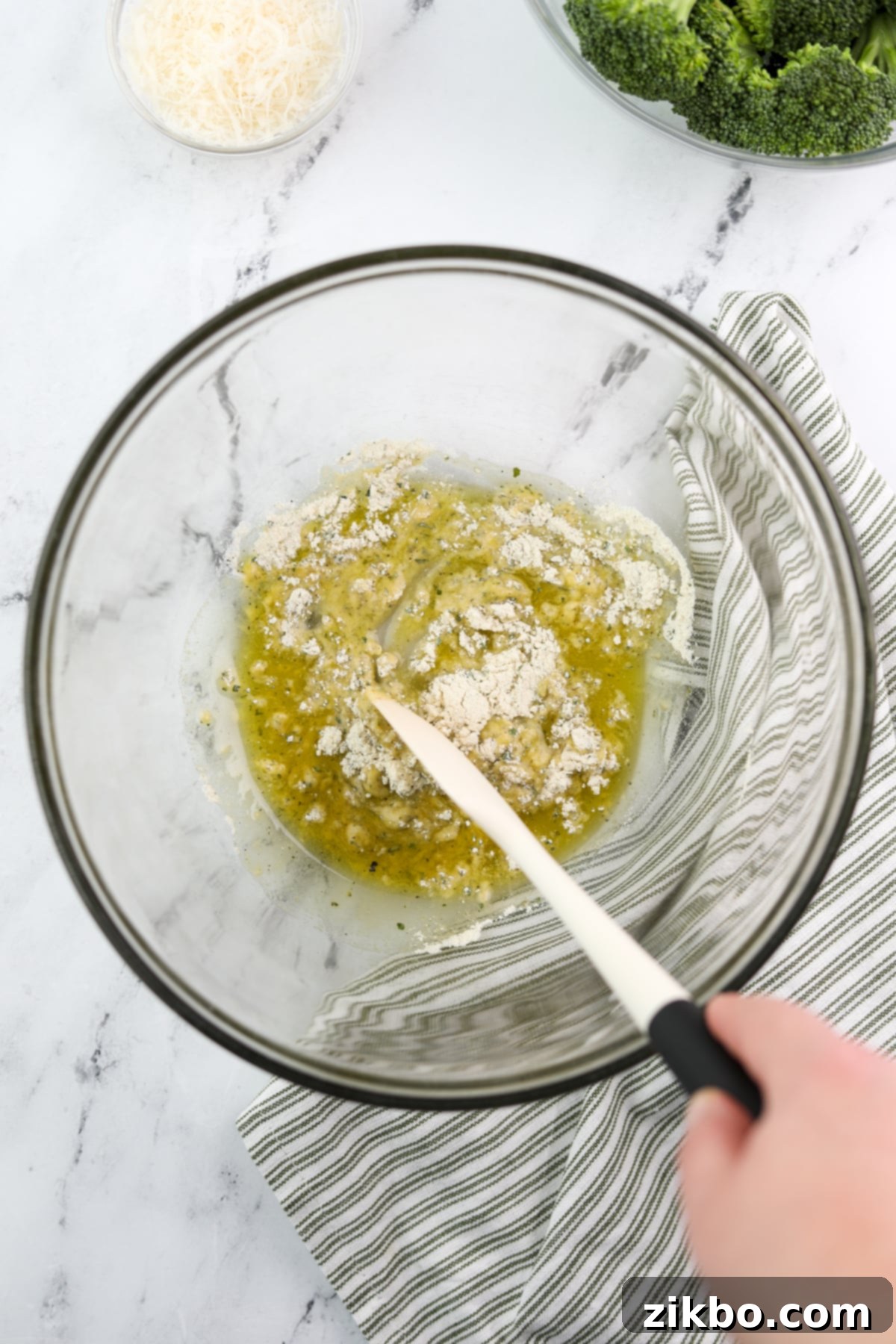 Stirring dry ranch seasoning into olive oil to create a smooth, seasoned paste.