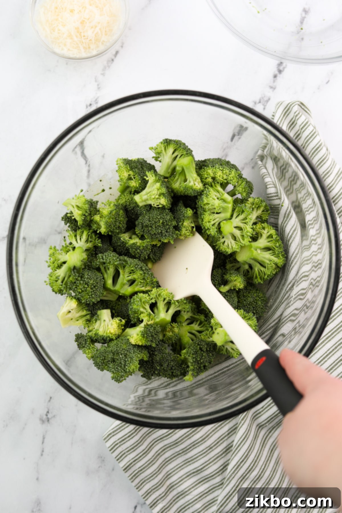 Tossing fresh broccoli florets into the ranch-seasoned olive oil mixture until every piece is evenly coated.
