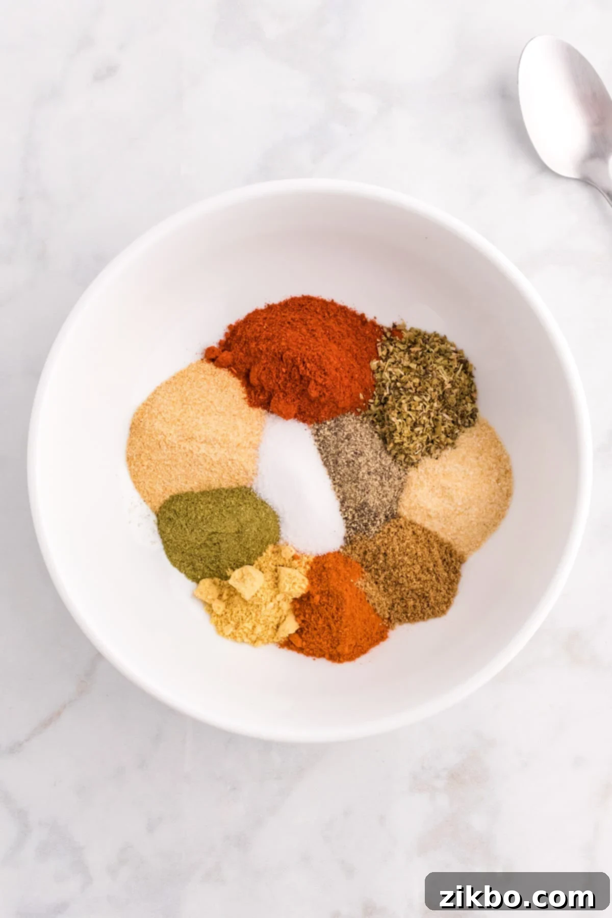 A small bowl featuring various spices, seasonings, salt, etc.