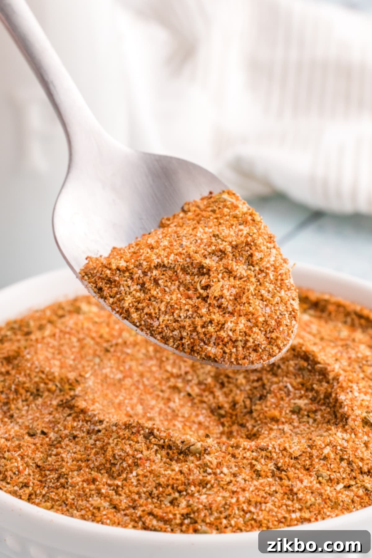 Cajun seasoning being spooned from a bowl.