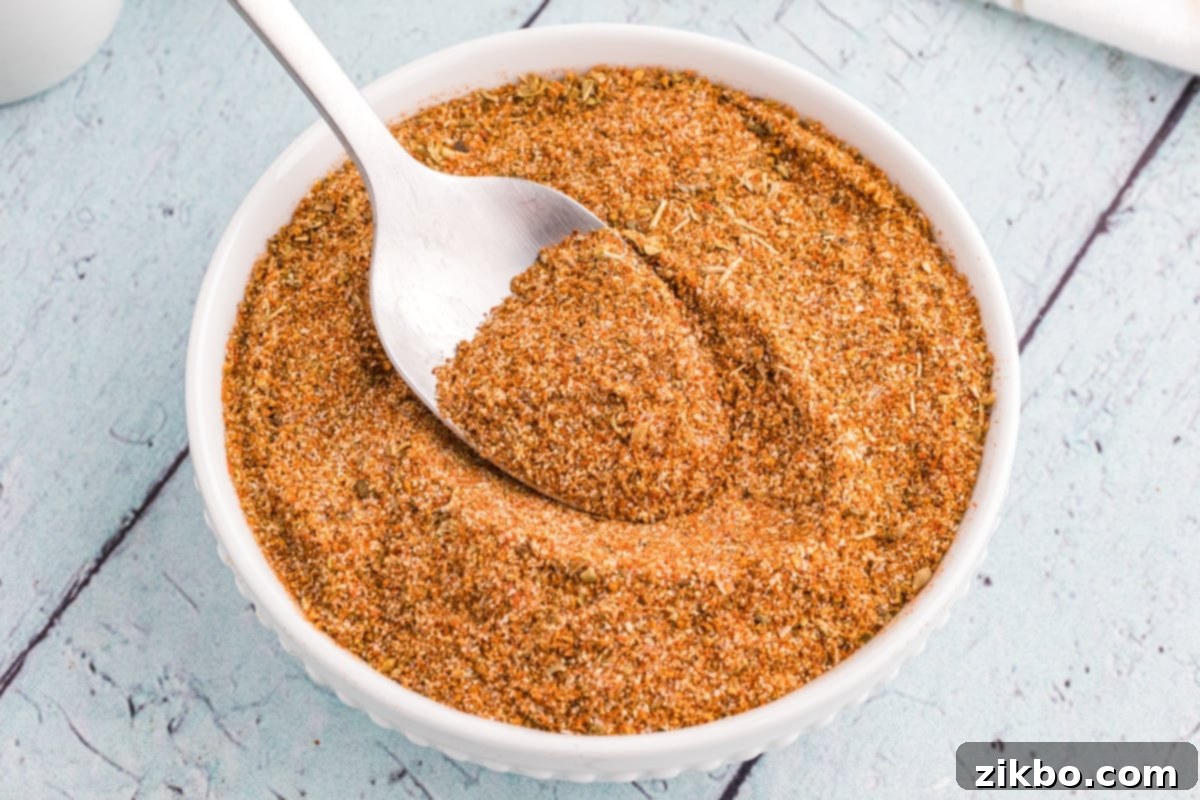 A small bowl with a homemade spice blend being spooned out.