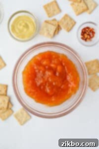 Pouring apricot preserves into a bowl for Jezebel sauce