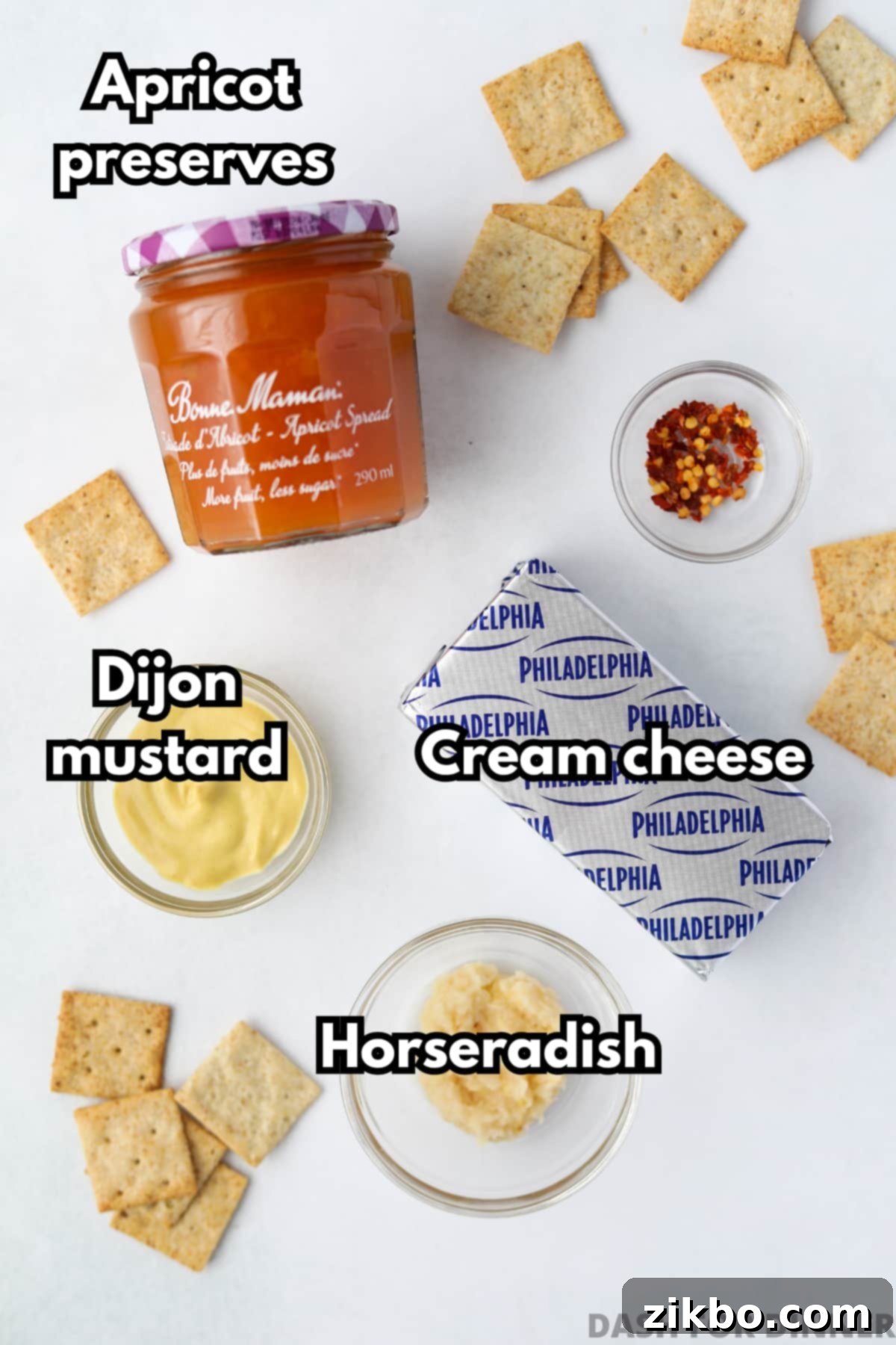 Spicy Southern Jezebel Dip 3 Individual ingredients for Hot Jezebel Dip: jar of apricot preserves, tube of dijon mustard, jar of prepared horseradish, and crushed red pepper flakes
