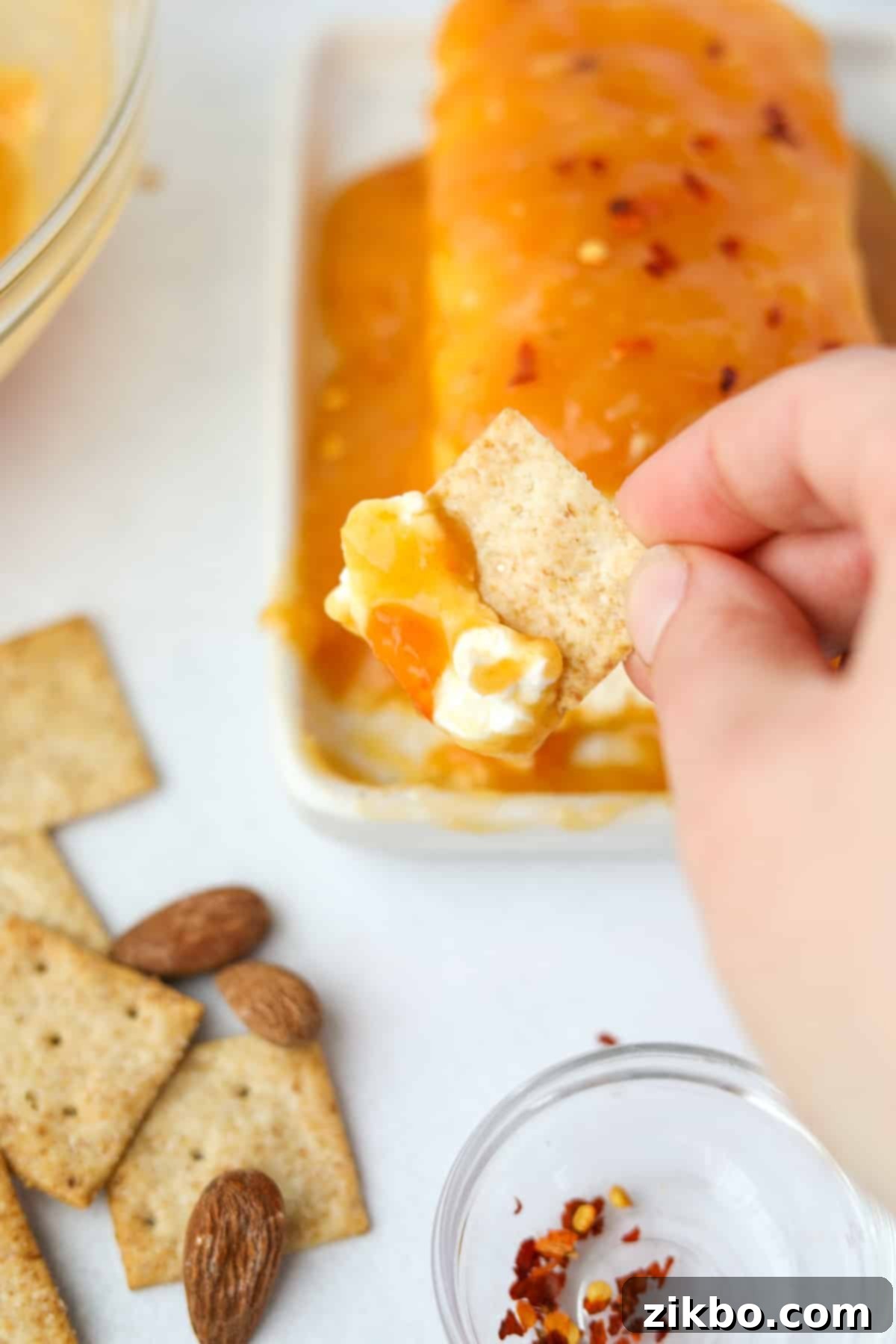 Spicy Southern Jezebel Dip 10 Close-up of Hot Jezebel Dip served with various crackers, garnished with red pepper flakes