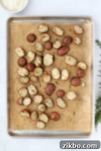 Roasted potatoes on a parchment lined sheet pan.