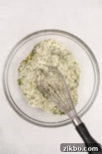 Whisking together herbs and buttermilk powder in a bowl.