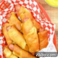 Crispy Air Fryer Pigs in a Blanket 10 A basket of pigs in a blanket in a red basket.
