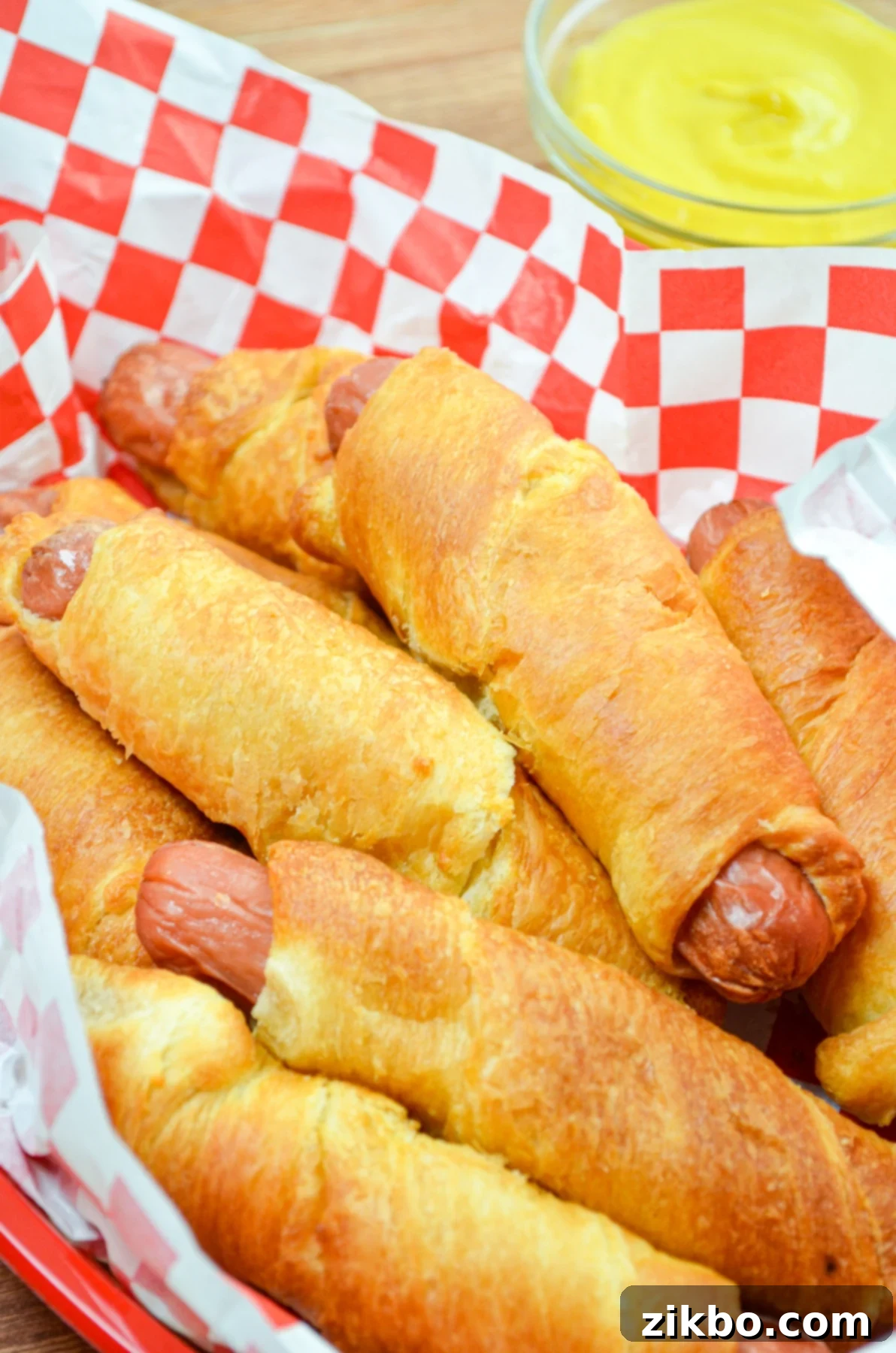 Crispy Air Fryer Pigs in a Blanket 8 A basket full of perfectly air-fried pigs in a blanket, golden and puffy.