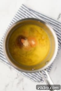 A pot filled with melted butter and seasonings.