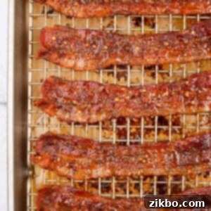A wire cooking rack filled with cooked bacon that's been candied with brown sugar and crushed chilies, ready to be enjoyed.