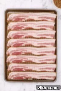 A baking sheet filled with bacon slices, neatly arranged on a wire rack.