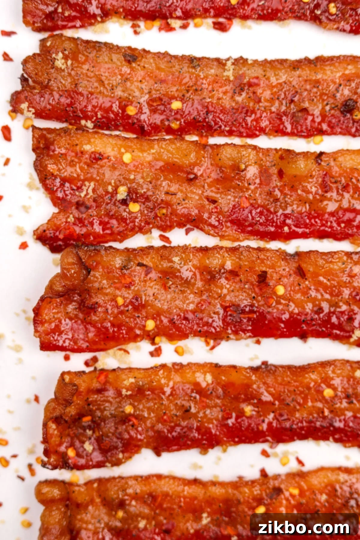 Slices of millionaire's bacon, coated with a sweet and spicy glaze and a sprinkle of red pepper flakes.
