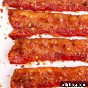 Slices of millionaire's bacon, dotted with red pepper flakes and glazed with brown sugar, making for a perfect sweet and spicy treat.