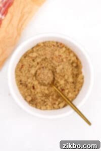 A small bowl of the well-mixed brown sugar spice rub with a gold spoon.