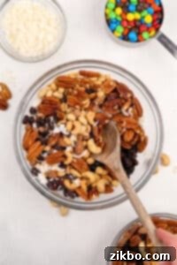 A large bowl filled with mixed nuts, dried fruit, and coconut.