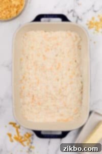 Hash brown casserole spread into a baking dish.