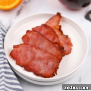 A small plate with four crispy slices of back bacon.
