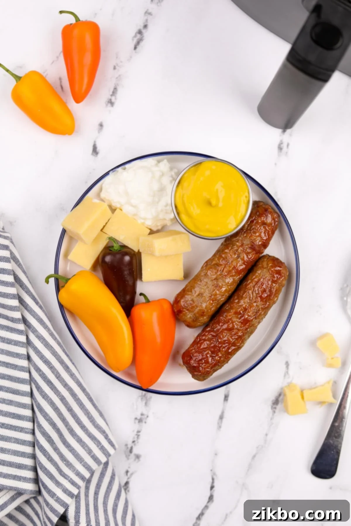 A vibrant plate featuring perfectly cooked air fryer chicken sausages, surrounded by fresh green vegetables, a dollop of creamy cottage cheese, and a side of classic mustard.