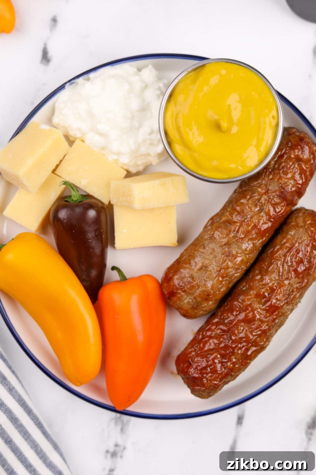 A rustic wooden board holds a wholesome meal: neatly sliced air fryer chicken sausages, alongside a variety of fresh vegetables and chunks of flavorful cheese.